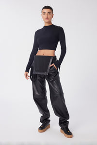 Maya is wearing a size 26 Overalls in Leather in color Black by LITA, view 5