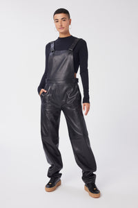 Maya is wearing a size 26 Overalls in Leather in color Black by LITA, view 1
