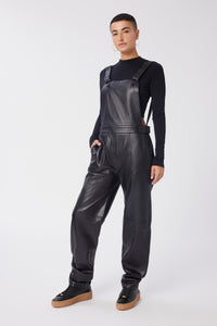 Maya is wearing a size 26 Overalls in Leather in color Black by LITA, view 2