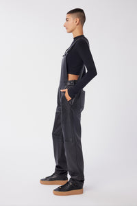 Maya is wearing a size 26 Overalls in Leather in color Black by LITA, view 3