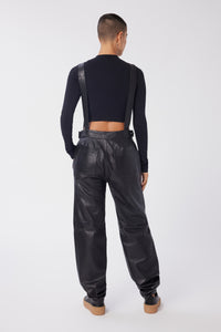 Maya is wearing a size 26 Overalls in Leather in color Black by LITA, view 4